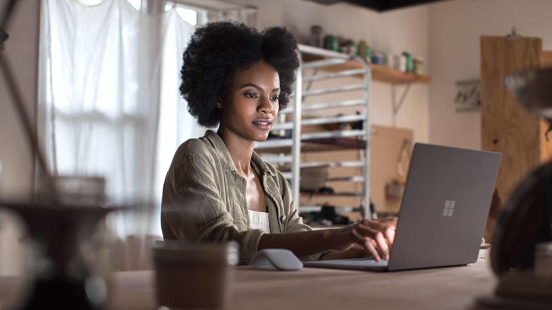 African American woman sitting in front of a laptop pointing at the screen
