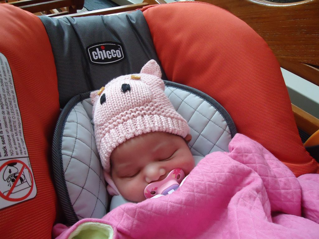 baby with pink pig beanie on head